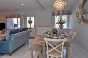 a living room with a table and a blue couch at Finest Retreats - Sisu Bakewell, Limestones Cottage in Bakewell