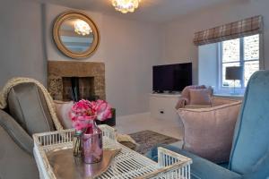 a living room with a vase of flowers on a table at Finest Retreats - Sisu Bakewell, Limestones Cottage in Bakewell