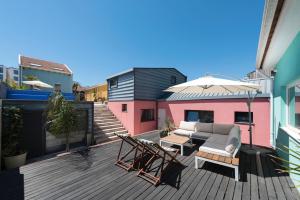 een patio met een bank en een parasol op een terras bij Fred's House Asprela in Porto