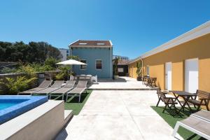 a patio with chairs and a swimming pool next to a building at Fred's House Asprela in Porto