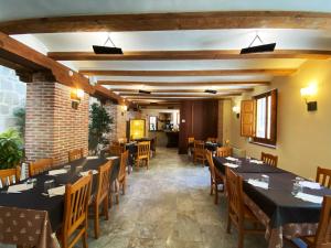 ein Restaurant mit Tischen und Stühlen und einer Backsteinmauer in der Unterkunft HOTEL EL RASTRO - Palacio Duque de Tamames - in Avila