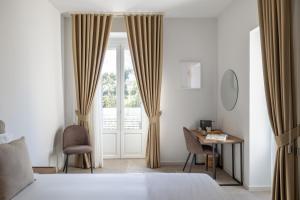 a bedroom with a bed and a desk and a window at Portamarina in Vieste