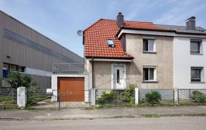 uma casa com uma porta laranja ao lado de um edifício em Ferienhaus AyNa em Bad Säckingen