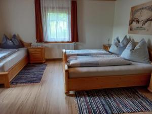 1 dormitorio con 2 camas y ventana en Steurer Hof, en Liebenfels