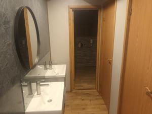 La salle de bains est pourvue de 2 lavabos et d'un grand miroir. dans l'établissement Varbla sadam ja restoran Groot, 