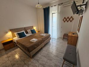 a bedroom with a bed and a television in it at Fotini's Apartments - Pelekas Beach in Pelekas