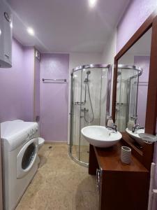 uma casa de banho com um chuveiro, um lavatório e uma máquina de lavar roupa em Sea View Rental Iglika Apartments em Golden Sands