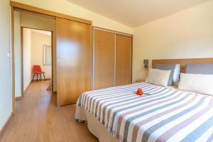 a bedroom with a bed with a flower on it at Spacious apartment with pool in Prazeres - 150m² in Campanário