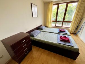 a bedroom with a bed and a dresser and a window at Julia Vigo Panorama apartments in Nesebar