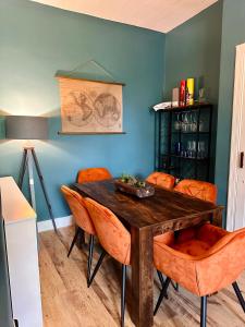 爱丁堡Wee one Flat share accomodation的一间有木桌和橙色椅子的餐厅 更多2张照片