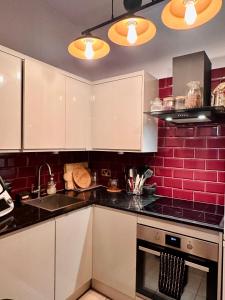 爱丁堡Wee one Flat share accomodation的厨房配有白色橱柜和红砖墙