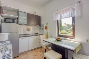 una cucina con mobili bianchi e un piano di lavoro di Casa Luka Vareski a Krnica