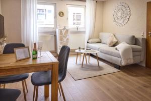 a living room with a table and a couch at IDEE Living: City Apartment am Marktplatz in Heppenheim an der Bergstrasse