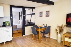 a room with a table and chairs and a bedroom at IDEE Living: City Apartment am Marktplatz in Heppenheim an der Bergstrasse