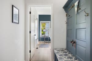 a hallway with a blue door and a rug at Greystone Cottage in Union Pier
