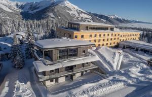 a building covered in snow in front of a mountain at AppartMO - Zillertal Arena, Hohe Tauern, Salzburgerland, Krimml, Hochkrimml in Krimml