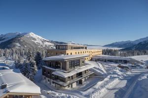 克里姆爾的住宿－AppartMO - Zillertal Arena, Hohe Tauern, Salzburgerland, Krimml, Hochkrimml，一座被雪覆盖的建筑,背景是群山