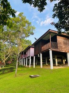 un edificio con terraza en un campo de césped en LiLLA Hilltop Retreats Janda Baik formerly known as Serene Resort, en Bentong
