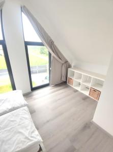 une chambre avec un lit et une grande fenêtre dans l'établissement Ferienhaus Mila 70qm bis 5 Gäste mit Fass-Sauna, Whirlpool April bis Oktober, 75qm Terrasse und eingezäunten Garten Haustiere willkommen, à Sierosław