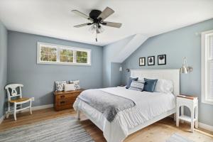 a bedroom with blue walls and a bed with a ceiling fan at Greystone Cottage in Union Pier