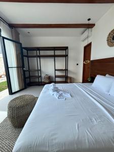 une chambre avec un grand lit blanc et une chaise dans l'établissement Villa Erita, stylish and beautiful villa in Nyang Nyang, à Uluwatu 15 autres photos