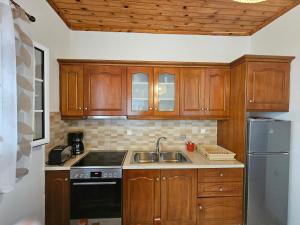 a kitchen with wooden cabinets and a sink at Fotini's Apartments - Pelekas Beach in Pelekas
