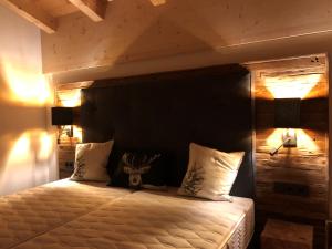 1 dormitorio con 1 cama con cabecero de madera en Filzstein Resort Chalet - Zillertal Arena, Hohe Tauern, Salzburgerland, Krimml, Hochkrimml, en Krimml