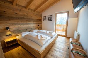 un lit dans une chambre avec un mur en bois dans l'établissement Filzsteinresort Chalets Chalet Bergankunft 236, à Krimml