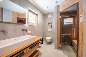 une salle de bain avec un lavabo et des toilettes dans l'établissement Filzsteinresort Chalets - Chalet 238, à Krimml 7 autres photos
