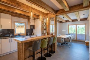 une cuisine avec des plafonds en bois et une table avec des chaises dans l'établissement Filzsteinresort Chalets - Chalet 238, à Krimml