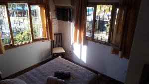 a bedroom with two windows and a bed in it at Departamento Independiente con Terraza in La Cieneguita