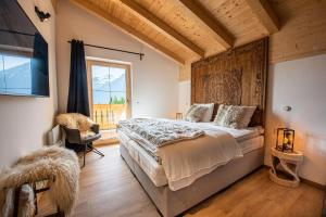 a bedroom with a large bed and a window at Filzsteinresort Chalets - Chalet 237 in Krimml