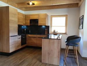 une cuisine avec des armoires en bois et un comptoir noir dans l'établissement Filzsteinresort Chalets - Chalet 240, à Krimml 8 autres photos