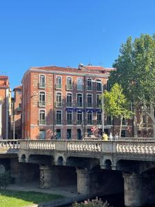 un pont sur une rivière avec des bâtiments en arrière-plan dans l'établissement Hotel De France, à Perpignan