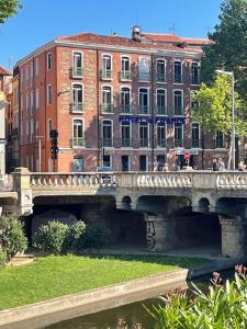 un pont sur une rivière devant les bâtiments dans l'établissement Hotel De France, à Perpignan