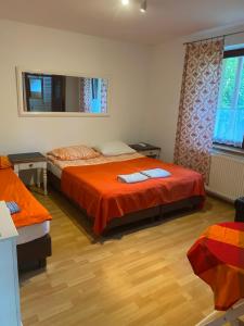 sypialnia z 2 łóżkami i pomarańczową pościelą w obiekcie Agroturystyka Pod Podkową w mieście Mrągowo