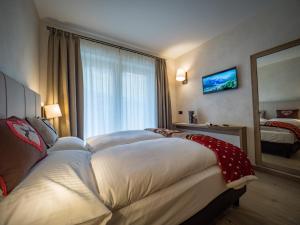 um quarto de hotel com uma cama e uma grande janela em Chalet Dolce Vita em Livigno
