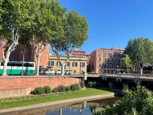 a bridge over a river in a city with buildings at Hotel De France in Perpignan