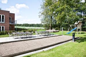 ein Spielplatz mit Tischen und Stühlen und einer Rutsche in der Unterkunft Montra Hotel Sabro Kro in Sabro