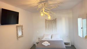 sypialnia z łóżkiem i żyrandolem w obiekcie Prickly Pear House w mieście Plaka Milou