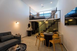 un soggiorno con scala, tavolo e sedie di EcoHeaven Suites ad Amoudara Herakliou