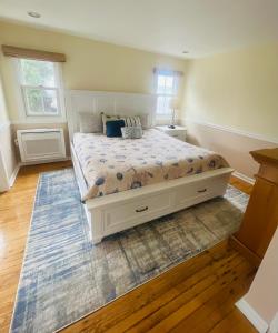 ein Schlafzimmer mit einem weißen Bett mit einer blauen Decke in der Unterkunft The Grenville Hotel and Restaurant in Bay Head