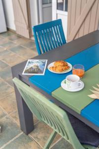 - une table avec une assiette de nourriture et une tasse de café dans l'établissement Maison de 2 chambres avec piscine partagee jardin clos et wifi a Saint Francois a 3 km de la plage, à Saint-François