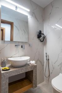y baño con lavabo blanco y espejo. en FYSIOPHYLIA VILLAS, en Frangokastello