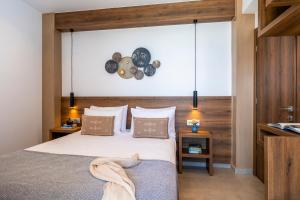 1 dormitorio con 1 cama y reloj en la pared en FYSIOPHYLIA VILLAS, en Frangokastello