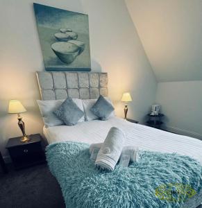 um quarto com uma cama com um cobertor e 2 candeeiros em Royal Marine Hotel Dunoon em Kirn