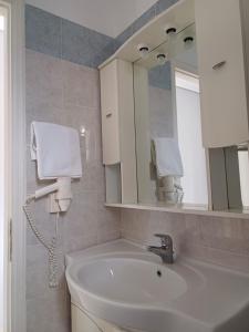 a bathroom with a sink and a mirror at Aktaion apartments in Artemísion +22 photos