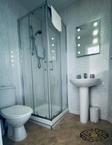 uma casa de banho com um chuveiro, um WC e um lavatório. em Royal Marine Hotel Dunoon em Kirn