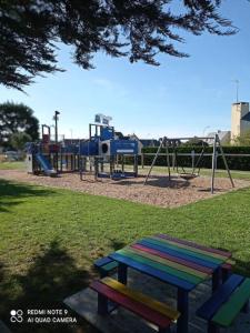 a park with a picnic table and a playground at Maison au calme bord de mer in Jullouville-les-Pins