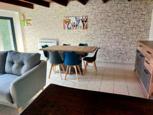a living room with a wooden table and blue chairs at Maison au calme bord de mer in Jullouville-les-Pins